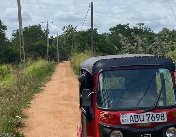 Rode tuktuk Rode tuktuk op een onverharde weg in SriLanka